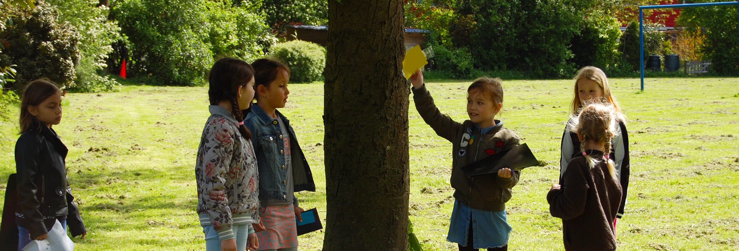 Een groep jongens en meisjes is bezig met een speurtocht